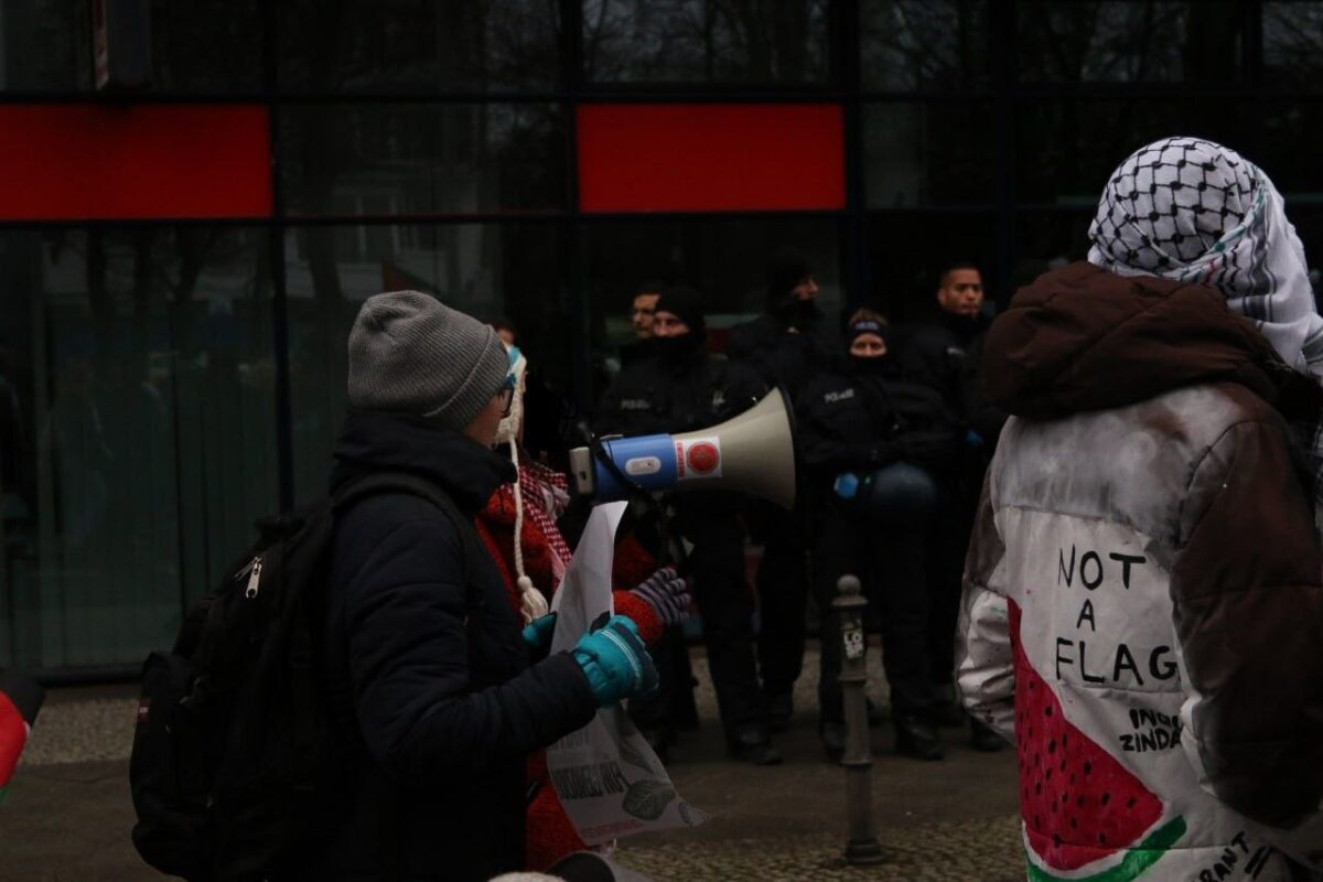 Protestors walk past the police